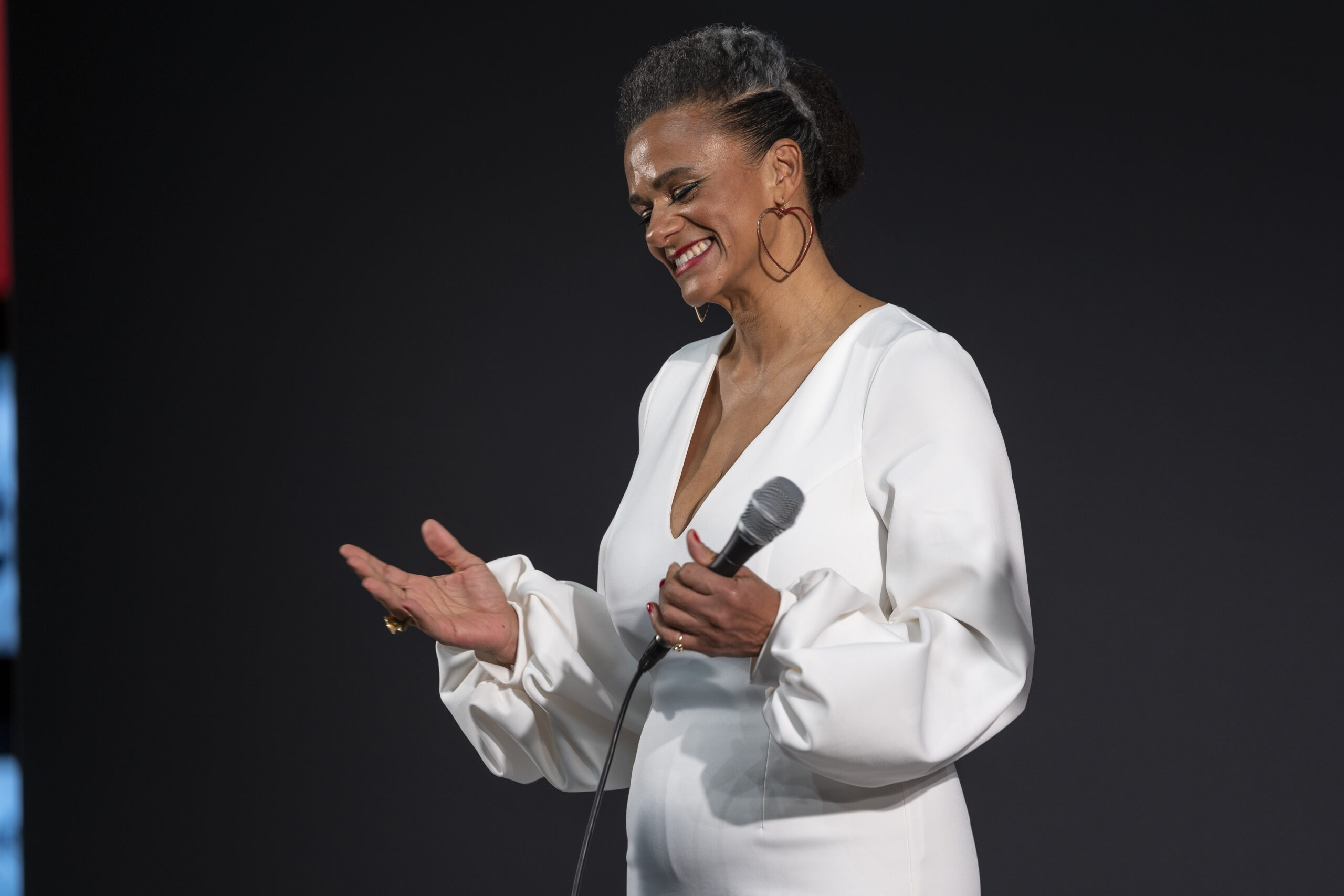 Aayana Batô bei einem Live-Auftritt im weißen Kleid auf der Eventbühne.